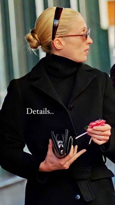 a woman in black coat holding an umbrella and cell phone with caption detailing details