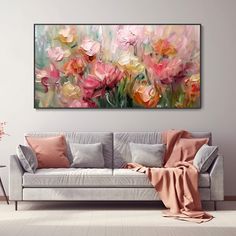 a living room with a couch and painting on the wall above it that has pink flowers