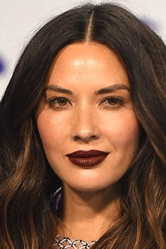 a woman with long brown hair and dark lipstick