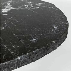 a black marble table top with white veining on it's edges and bottom