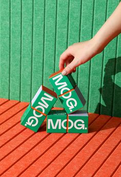 a person is placing three boxes on top of each other with the word mog written on them