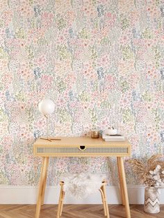 a small table with a lamp on top of it next to a wallpapered wall