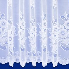 white lace curtains with flowers and leaves on the top are hanging in front of a blue background