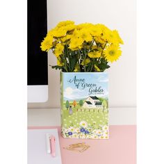 a bouquet of yellow flowers sitting on top of a desk