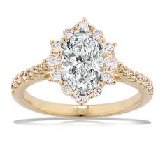 a yellow gold engagement ring with an oval cut diamond surrounded by small white and yellow diamonds