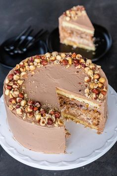 there is a chocolate cake with nuts on the top and one slice missing from it