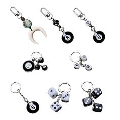 six different key chains with dices and charms attached to them, all in black and white