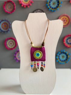 a necklace with an evil eye and beads hanging from it's end on a mannequin head