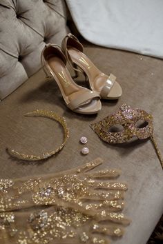 a pair of shoes, headbands and mask are on a chair with gold sequins