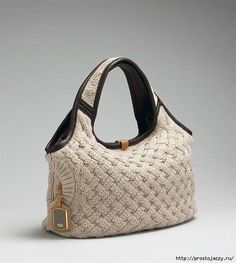 a white purse with black handles on a gray background