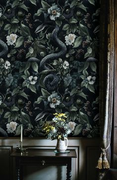 a vase with flowers sitting on a table in front of a wallpapered background