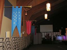 an auditorium with chairs and banners hanging from the ceiling