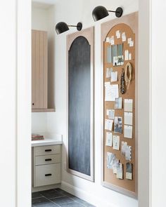 a kitchen with two bulletin boards on the wall next to a counter top and cabinets