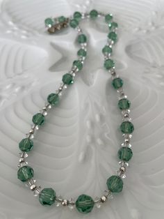 Vintage French Crystal Necklace, Sparkling Green Lovely and original very vintage French crystal necklace. Soft green faceted crystal with small clear spaces and tiny silver beads, all strung on fine silver chin. Gorgeous color and lots of sparkle. 18.5 inches long. Ornate bar clasp is missing on stone.  Found outside Antibes. Shipping will resume on Oct. 28 when I return from France. Silver Crystal Necklace With Spacer Beads As Gift, Crystal Necklaces With Silver Beads For Gift, Crystal Necklaces With Silver Beads As Gift, Crystal Beaded Necklaces With Silver Beads As A Gift, Green Crystal Beaded Necklaces As Gift, Green Crystal Beaded Necklace For Gift, Green Sterling Silver Beaded Necklace With Silver Beads, Green Czech Glass Crystal Necklace For Gift, Gift Czech Glass Green Crystal Necklace