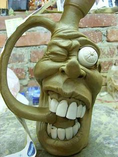 a clay sculpture of an evil looking head holding a baseball bat