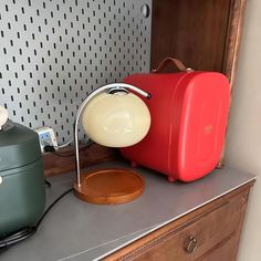 a red piece of luggage sitting on top of a counter next to a green one