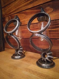 two metal sculptures sitting on top of a wooden table