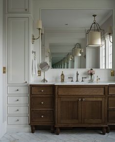 a bathroom vanity with two sinks and mirrors