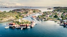 an island in the middle of water with boats and houses on it's sides