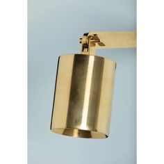 a brass colored light fixture hanging from the side of a blue wall with a white background