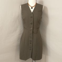 90's Vintage Button Front Sleeveless Jumper - Long Gillet Vest. Brown Herringbone Wool Fabric, Bronze Buttons And Pocket Chain. Marked Size 40, Shown On A 2 Dress Form Please Go By Measurements. Length 36" In Front At Point, 34.5" In Back, Shoulders 16", Pit To Pit 17", Waist 27", Hips 36". Condition Very Good, Looks Unworn But One Flaw - See Last Two Pics Including Close Up Pic. Versatile Piece, Great For Layering. Nice Example Of Italian Quality And Designer Panache. Timeless, Classic. Fitted Sleeveless Khaki Dress, Fitted Casual Vest With Buttons, Fitted Sleeveless Dress With Side Buttons, Fitted Khaki Vest For Work, Retro Fitted Vest With Button Closure, Fitted Retro Vest With Button Closure, Fitted Brown Vest With Button Closure, Vintage Summer Vest For Workwear, Retro Fitted Sleeveless Vest