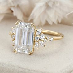 a ring with an emerald cut diamond surrounded by small diamonds