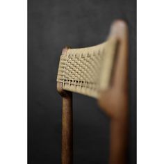 a close up view of a wooden chair with woven fabric on it's back