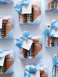 six gift boxes with cookies wrapped in blue ribbon