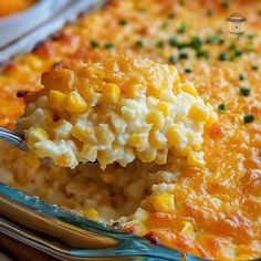 a spoonful of macaroni and cheese is being lifted from a casserole dish