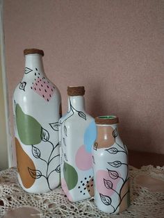 three vases are sitting on a lace tablecloth