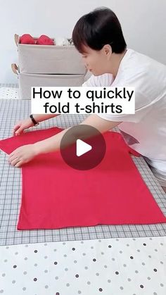 a woman is making a t - shirt out of red material on a table with the words how to quickly fold t - shirts