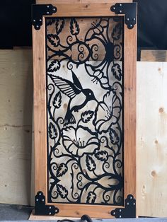 a wooden frame with a bird and leaves design on the front, sitting next to a pair of scissors