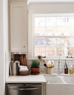 a kitchen with a sink, dishwasher and window