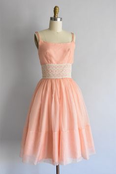 "Vintage 1950s chiffon dress. Peachy nylon chiffon with a delicate white crochet lace waistline. Double spaghetti strap, darted bust and nipped waist. Full skirt with a back metal zipper closure. Fully lined. State of garment | very good, some wonky sewing at waistline and a small hole near hem (hard to detect due to lining). refer to photos & request further photos if needed. Measurements ✂--- best fit | extra small / small bust | 33 -34\" shoulders | not specified shoulder to waist | 15 \" Buoyant Spring, Vintage Dress Outfit, 50's Dresses, Vintage Pink Dress, 1950s Dresses, Cotton Frocks, Nylon Dress, 50's Style, Peachy Keen