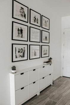 black and white pictures hang on the wall above a dresser