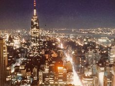 an aerial view of the city at night from top of a building in new york