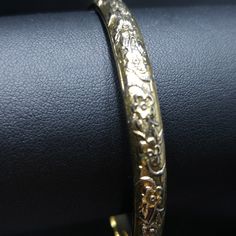 *Description: This is a great Whiting & Davis embossed gold tone floral bangle bracelet from the late 1960s to 1970s. The bracelet is in great condition and is signed on the inside of the bangle. This would be a great vintage bangle bracelet for your collection of Whiting & Davis and would also make a great gift. It would be the perfect bracelet to layer with other bangles. It is an over the hand bracelet, no clasp. *Approximate Measurements: Length - 7 1/2 Inches, Width - 1/4 Inch *Cond Gold Brass Bangle Bracelet For Formal Occasions, Classic Gold Brass Bangle Bracelet, Antique Gold Brass Bracelets For Formal Occasions, Formal Antique Gold Brass Bracelets, Classic Gold Bracelet Bangle In Brass, Formal Antique Gold Brass Bracelet, Antique Gold Cuff Bracelet Collectible, Antique Gold Cuff Bracelet For Formal Occasions, Classic Gold Etched Bangle