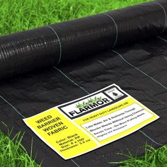 a roll of black tarp sitting on top of green grass next to a sticker