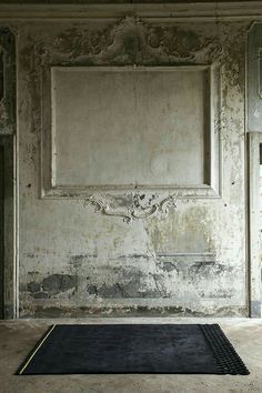 an old room with a door and rug in the floor next to two doors that are open