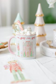 a cup filled with marshmallows sitting on top of a table next to other decorations