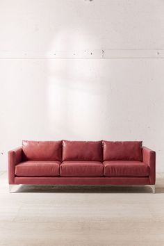 a red leather couch against a white wall