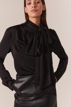 Trends with benefits. The Castian Satin Blouse has a relaxed silhouette that is dramatised by an exaggerated pussybow neckline. Imagined in classic black for a timeless and trans-seasonal look, this blouse is a work to weekend favourite.

SIZING: True to size. AU: Model wears a size 8 / US: Model wears a size 4.

FABRICATION: 100% Polyester

- Satin blouse
- Bow neckline with press stud
- Long loose sleeves Bardot Junior, Loose Sleeves, Satin Blouse, Party Tops, Polyester Satin, Blouse Black, Fashion Tops, Black Blouse, Skirt Length