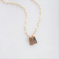 "Dainty Initial Charm Necklace . Dainty and meaningful, wear your favorite initials close to your heart. Choose 14kt gold filled or sterling silver options. These mini rectangle charms grace a drawn cable chain for a classic and minimal look. D E T A I L S -Rectangle Disc measures 10mm -Choose 14kt Gold-Filled or Sterling Silver - not plated. -A high quality drawn cable chain with a spring clasp. -Polished to a light satin finish. CUSTOM HAND STAMPING -Hand stamped with an initial or heart symbo 14k Gold Filled Initials Necklace For Everyday, Minimalist 14k Gold Filled Necklace For Personalized Gift, Meaningful Everyday Gold Name Necklace, Dainty Name Necklace With Charms For Everyday, Dainty Initial Necklace With Charms, Minimalist 14k Gold Filled Charm Necklace As Personalized Gift, Gold Sterling Silver Initial Necklace For Everyday, Dainty 14k Gold Filled Initials Charm Necklaces, Dainty 14k Gold Filled Initials Charm Necklace