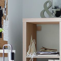 a shelf with papers and other items on it in a room next to a wall