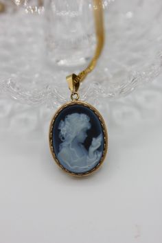 This natural hand carved Blue Agate Cameo Pendant in 14k Yellow Gold omits luxury and more! This amazing pendant is stylish and will always be a classic. This pendant is priceless and a collectible circa 1990. Dimensions: 19mm x 23mmCondition: Great, stone is flawlessStone: Blue Agate CameoMetal: 14k Yellow Gold **please note: all vintage jewelry is sold as is- no returns or exchanges** Luxury Cameo Pendant Jewelry, Luxury Oval Cameo Necklace, Luxury Blue Locket Necklace, Luxury Blue Locket Jewelry, Luxury Blue Carved Jewelry, Luxury Carved Blue Jewelry, Elegant Cameo Round Pendant Jewelry, Collectible Cameo Jewelry With Round Pendant, Collectible Cameo Round Pendant Jewelry