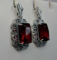 Simulated Red Ruby Solid Sterling Silver Earrings Short Festoon Design#E8z (shorter version) These Victorian reproduction estate earrings are solid sterling silver. These filigree earrings have stunning simulated red ruby gemstones. Each stunning gem is 10mm x 8mm x 5mm in dimension. The earrings are approximately 1/2" x 1" (13mm x 23mm). The unique earrings are marked 925 for solid sterling silver. These lovely earrings were refashioned from an antique Victorian cameo necklace. Quintessentially Red Jewelry Set, Jeweled Flowers, Armenian Jewelry, Red Stone Ring, Marcasite Jewelry, Filigree Jewelry, Mid Century Jewelry, Red Jewelry, Red Gemstones