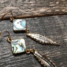 Who doesn't love a little shimmer in their life? Answer the siren's song and get a pair of these beauties for yourself or someone you love. Hand carved abalone feathers dangle from super iridescent abalone squares. The color in these is just amazing and my photos just can't seem to capture it. The perfect earrings to wear with jeans and a t-shirt, at the beach, or on vacation. High quality gold fill ear wires. Length : 3" Listing is for one pair. All of these are made from natural abalone shells Iridescent Mother Of Pearl Dangle Jewelry, Iridescent Mother Of Pearl Jewelry With Matching Earrings, Iridescent Abalone Shell Dangle Earrings, Iridescent Dangle Earrings From Abalone Shell, Iridescent Dangle Earrings With Abalone Shell, Gold Abalone Shell Earrings For Gifts, Iridescent Abalone Shell Dangle Jewelry, Adjustable Dangle Feather Jewelry, Dangle Feather Jewelry As A Gift