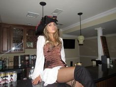 a woman in a pirate costume sitting on top of a counter