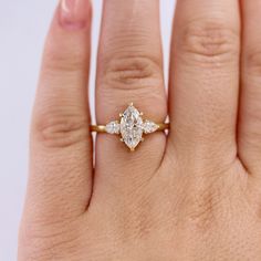 a woman's hand with a diamond ring on top of her finger, showing the center stone