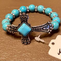 Southwest Turquoise Bead Cross Bracelet Elevate Your Everyday Style - And Beautifully Display Your Faith - With This Lovely Southwest Style Cross Bracelet. A Stunning Spiritual Style, Stretch Bracelet Beautifully Enhanced By Exquisite Color To Elevate Any Ensemble. Featuring Lustrous Compressed Turquoise Beads With A Religious, Sideways Cross Motif At Center. Measure: 6.75 Inch L X 0.94 Inch W, Weight: 21.74 Grams Stone: 10 Mm, Material: Alloy, Rhodium Plating, Compressed Turquoise Turquoise Beaded Stretch Bracelet Gift, Bohemian Blue Rosary Bracelet With Round Beads, Turquoise Hand-strung Stretch Bracelet, Spiritual Nickel-free Turquoise Beaded Bracelets, Adjustable Turquoise Rosary Bracelet With Round Beads, Turquoise Beaded Rosary Bracelet With Round Beads, Adjustable Turquoise Stretch Bracelet For Jewelry Making, Turquoise Beaded Bracelets With 8mm Beads, Spiritual Turquoise Beaded Stretch Bracelet